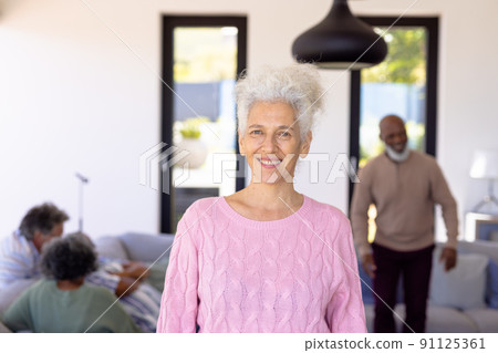 Portrait of smiling caucasian senior woman standing with multiracial friends in background 91125361