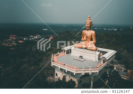 Thip Nimit Buddha statue over the city of Phetchaburi, Thailand Thip Nimit Buddha statue over the city of Phetchaburi, Thailand 91126147