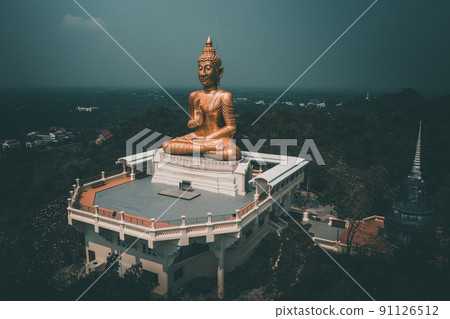 Thip Nimit Buddha statue over the city of Phetchaburi, Thailand Thip Nimit Buddha statue over the city of Phetchaburi, Thailand 91126512