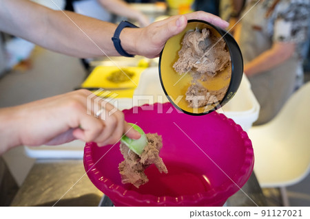 The process of making ray bread. Sourdough is added to the mixing container. Front view. 91127021