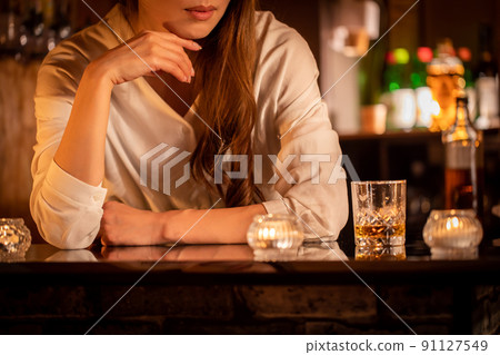 A woman wearing a cheek stick at the bar counter BAR 91127549