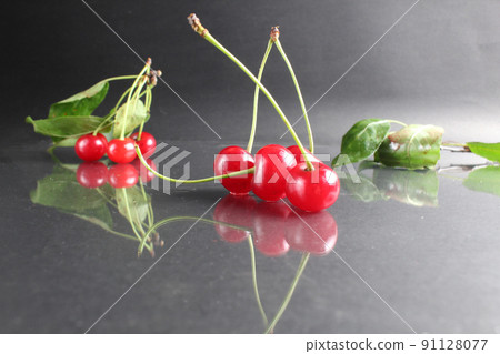summer seasonal berries of ripe red cherry on a black background close-up. Berry Dessert Delicacy Vitamins Benefits 91128077