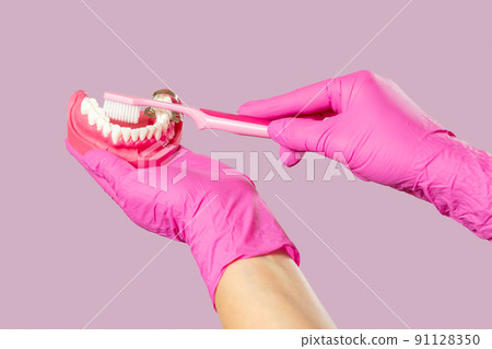 Dentist with toothbrush and layout of the human jaw. 91128350