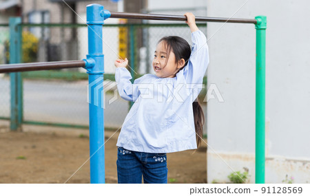 Girl working hard on the horizontal bar 91128569