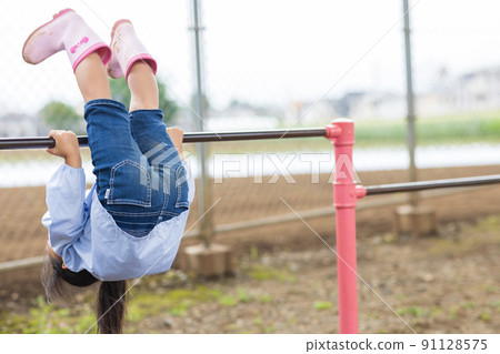 Girl working hard on the horizontal bar Girl working hard on the horizontal bar 91128575