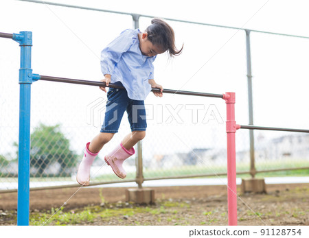 Girl working hard on the horizontal bar 91128754