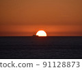 Sunset over the Atlantic Ocean and a cargo ship 1 91128873