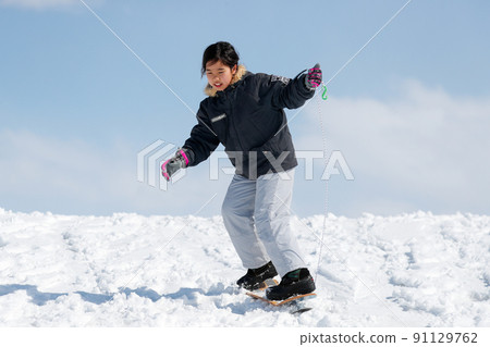 Girl sliding on the snow on snow skates Girl sliding on the snow on snow skates 91129762