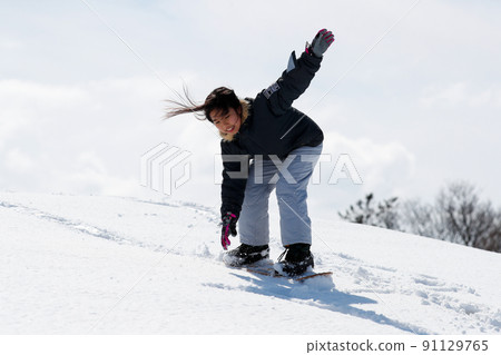 Girl sliding on the snow on snow skates Girl sliding on the snow on snow skates 91129765