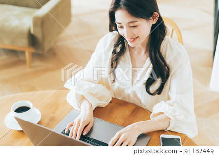 A woman using a personal computer at home A woman using a personal computer at home 91132449
