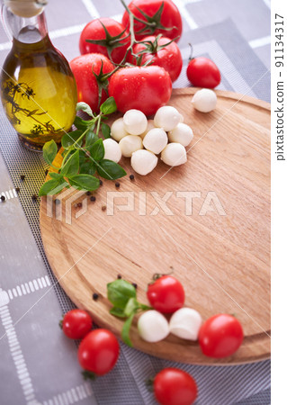 Ingredients for Caprese salad - Mini mozzarella cheese in glass bowl, tomato and basil Ingredients for Caprese salad - Mini mozzarella cheese in glass bowl, tomato and basil 91134317