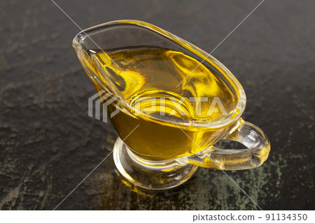 Bowl with olive oil on black wood background. 91134350