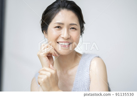 一個 50 多歲的女人的美麗形象肖像，她微笑著看著相機 91135530