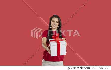 Smiling woman offer wrapped gift box Smiling woman offer wrapped gift box 91136122