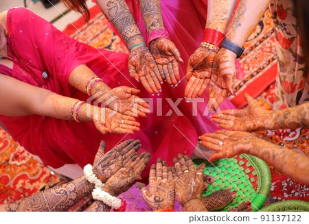 Indian women with henna tattoos and traditional clothes / sari Indian women with henna tattoos and traditional clothes / sari 91137122