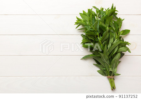 Fresh mint bunch on colored table. Top view with copy space Fresh mint bunch on colored table. Top view with copy space 91137252
