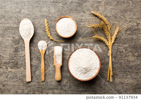 Flat lay of Wheat flour in wooden bowl with wheat spikelets on colored background. world wheat crisis 91137934