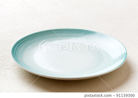 Perspective view of empty blue plate on cement background. Empty space for your design Perspective view of empty blue plate on cement background. Empty space for your design 91139300