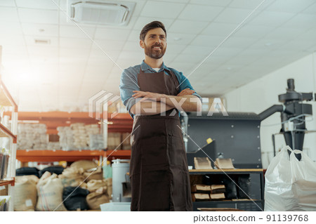 Portrait of smiling business owner on background of own small coffee factory 91139768