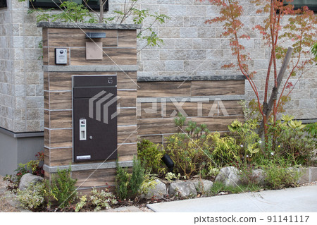 The gatepost of a detached house with elegant wood-grain tiles in a calm atmosphere where the autumn leaves shine beautifully The gatepost of a detached house with elegant wood-grain tiles in a calm atmosphere where the autumn leaves shine beautifully 91141117