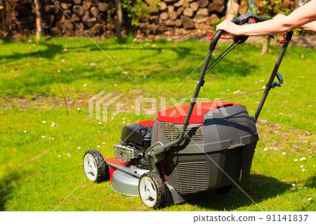 Gardening. Mowing green lawn with red lawnmower Gardening. Mowing green lawn with red lawnmower 91141837
