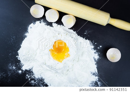 flour and egg on a black background. flour and egg on a black background. 91142351