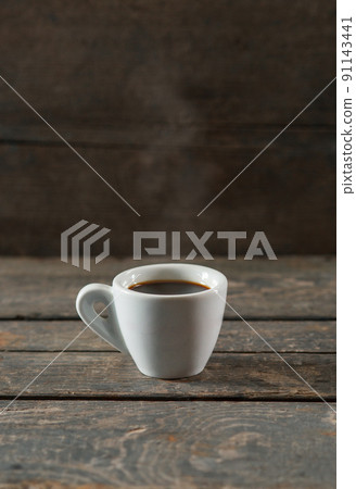 Hot black coffee or espresso in white ceramic cup on wooden texture background with steam Hot black coffee or espresso in white ceramic cup on wooden texture background with steam 91143441