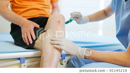 doctor examining patient knee doctor examining patient knee 91145219