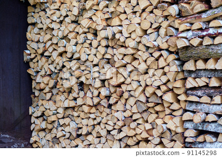 Neatly stacked birch firewood in the yard of the house 91145298