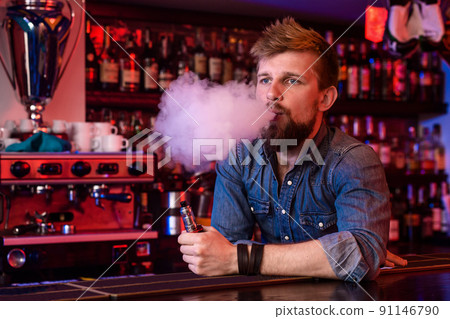 Vape. Vaping man in a cloud of vapor. Photo is taken in a vape bar. 91146790