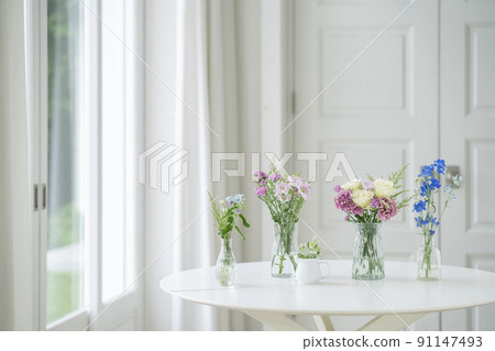 一張白桌，窗台上放著一個花瓶，與鮮花一起生活的形象 91147493