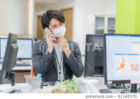 一個戴著面具在辦公室工作的年輕商人 91148370