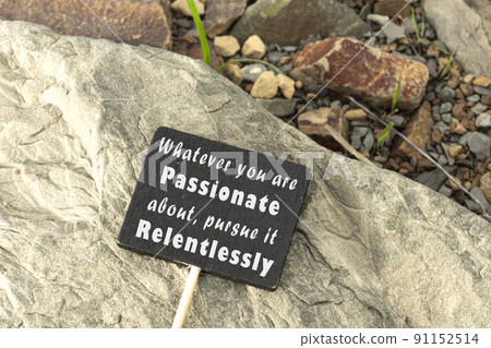 Motivational and inspirational quote on chalkboard on stone beach background. 91152514