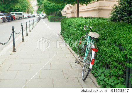 A vintage bicycle against green nature plant wall on a cobbled street. Healthy lifestyle and environmental form of transport. A vintage bicycle against green nature plant wall on a cobbled street. Healthy lifestyle and environmental form of transport. 91153247