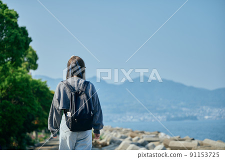 Gen Z women walking along the coast 91153725