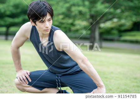 A young foreign man stretching in the fresh green 91154785