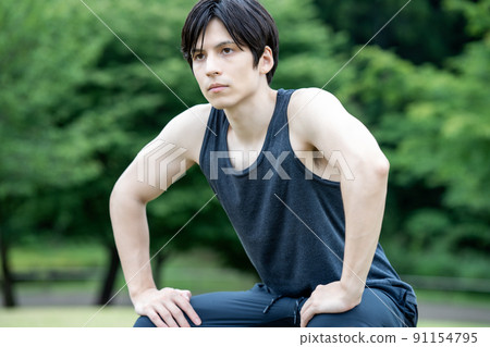 A young foreign man stretching in the fresh green 91154795