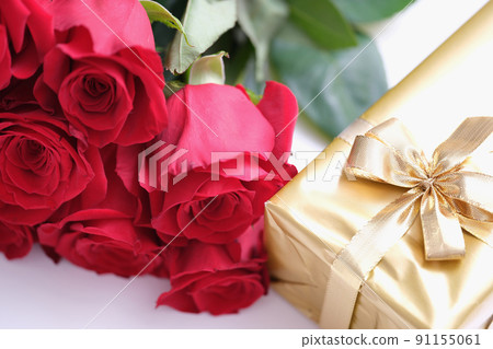 Gift box for Valentine Day tied with golden satin ribbon bow and beautiful roses 91155061