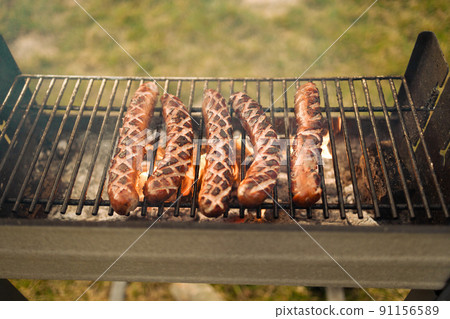 Delicious sausage on grill with spices and herbs on the flaming grill. Selective focus. Delicious sausage on grill with spices and herbs on the flaming grill. Selective focus. 91156589