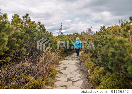 Portrait of a beautiful 50s blonde woman with a backpack in the mountains. Banner of hiker on adventure trek. 91156842