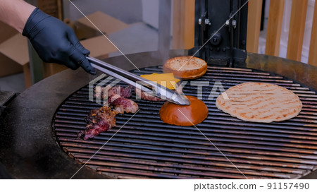 Chef cooking pieces of meat, burgers bums, cutlet and pita on grill - close up 91157490