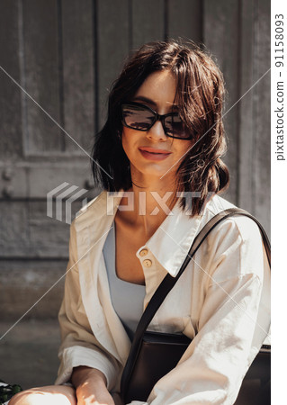 Vertical Portrait of the Fashionable Young Brunette Woman in Sunglasses Outdoors 91158093
