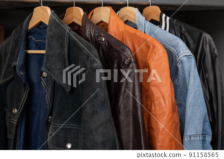 Various vintage jackets on clothing rack in second hand store 91158565
