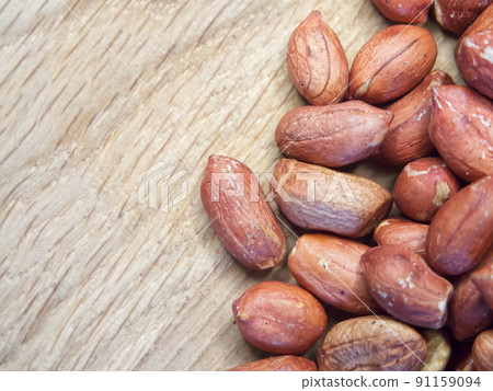 Macro image of roasted peanuts on a wooden background. A place for text, copy space. 91159094