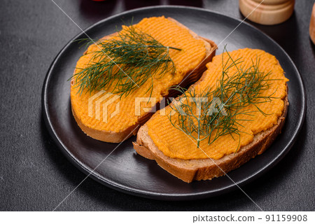 Delicious squash caviar sandwiches on a dark concrete background, healthy breakfast Delicious squash caviar sandwiches on a dark concrete background, healthy breakfast 91159908