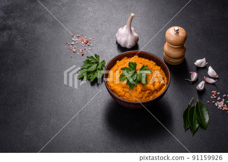 Squash caviar with garlic and tomatoes in a rustic bowl on a dark background 91159926