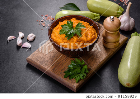 Squash caviar with garlic and tomatoes in a rustic bowl on a dark background 91159929