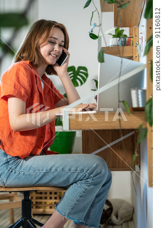 Young woman working on laptop at home. Cozy home office workplace, remote work or learning concept.  91160812