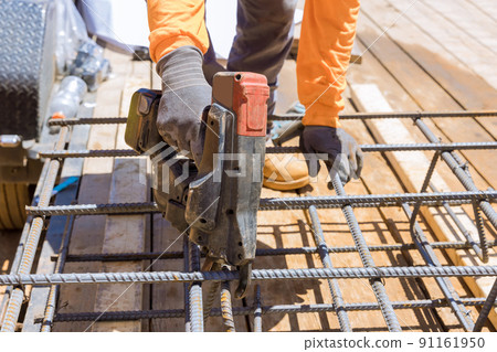 Using this tool, construction workers twist reinforcement wires with steel bars for cement foundations Using this tool, construction workers twist reinforcement wires with steel bars for cement foundations 91161950
