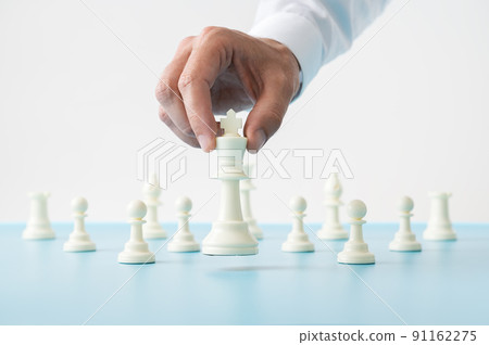 Hand holding chess figure of king in the position of power 91162275